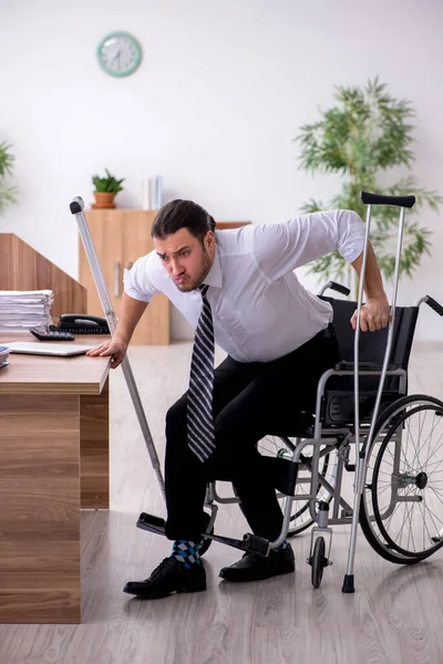 Młody niepełnosprawny pracownik cierpiący w miejscu pracy — Zdjęcie stockowe