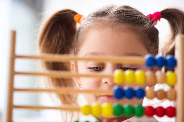 Kleines Mädchen mit Abakus im Klassenzimmer — Stockfoto