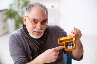 Atölyede çalışan yaşlı bir erkek saatçi.