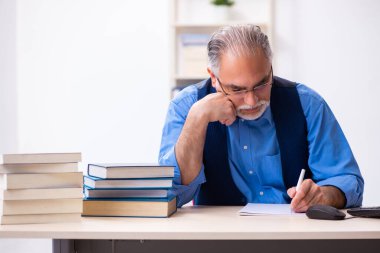 Kitap yazan yaşlı bir erkek yazar.