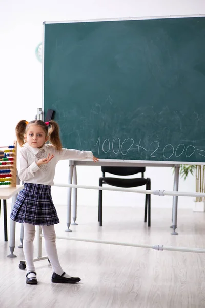 Klein meisje voor schoolbord in de klas — Stockfoto