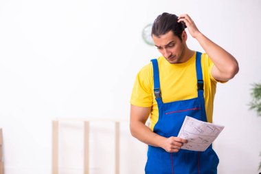 Genç erkek marangoz içeride çalışıyor.