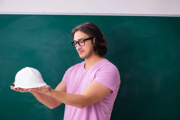 Young male student in front of board — Stock Photo, Image