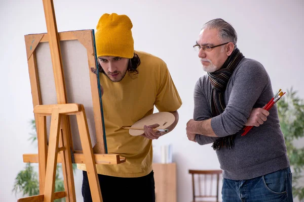 Viejo tomando lecciones de joven pintor —  Fotos de Stock