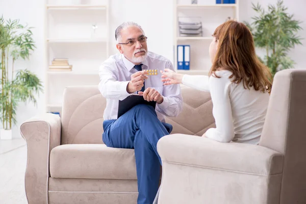 Mujer joven visitando viejo médico psicólogo — Foto de Stock