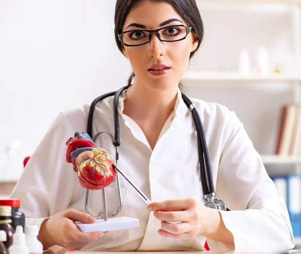 Mulher médico mostrando modelo de coração para estudantes — Fotografia de Stock