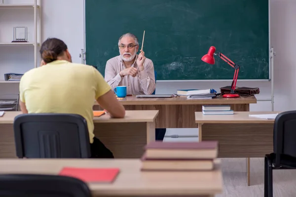 Velho professor e jovem estudante do sexo masculino na sala de aula — Fotografia de Stock