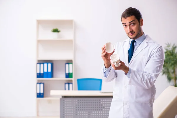 Young male doctor holding skull — Stock Photo, Image