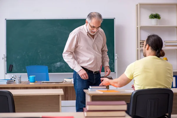 Viejo profesor y joven estudiante masculino en el aula —  Fotos de Stock