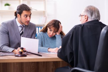 Yargıç ve avukatla birlikte adliyede genç bir kadın.