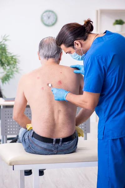 Viejo visitando joven médico dermatólogo — Foto de Stock