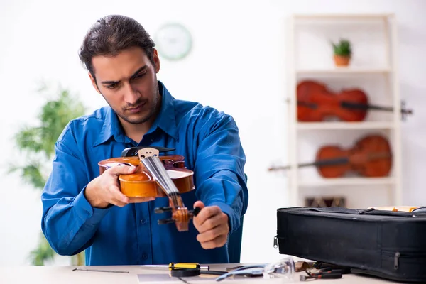 Jeune réparateur masculin réparant violon — Photo