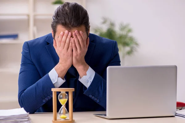 Joven empleado masculino en concepto de gestión del tiempo —  Fotos de Stock