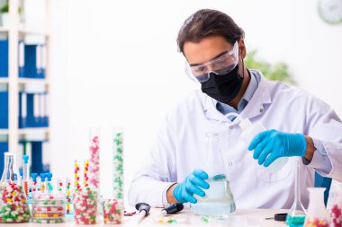 Genç erkek kimyager uyuşturucu sentezi konseptinde
