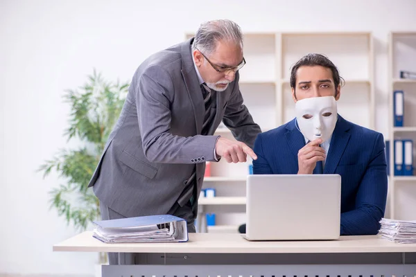 Oude baas en jonge mannelijke werknemer dragen maskers — Stockfoto