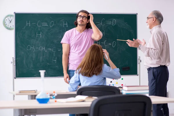 Oude scheikundeleraar en twee leerlingen in de klas — Stockfoto