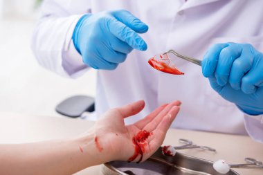Yaralı kadın erkek doktoru ziyaret ediyor.