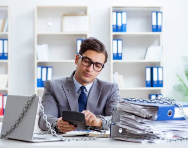 Ofis masasına zincirlenmiş meşgul bir çalışan.