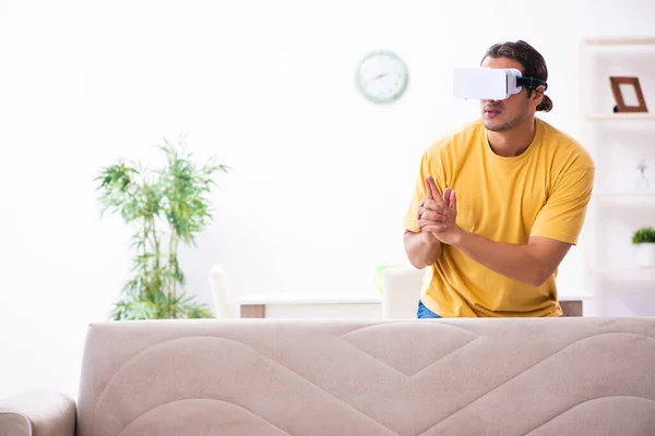 Jovem com óculos de realidade virtual em casa — Fotografia de Stock