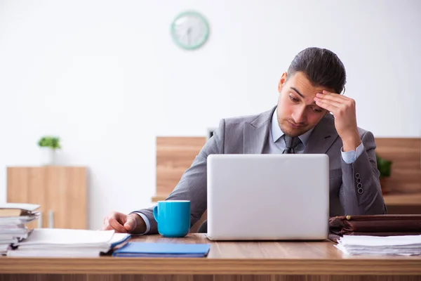 Joven empleado masculino infeliz con el trabajo excesivo —  Fotos de Stock