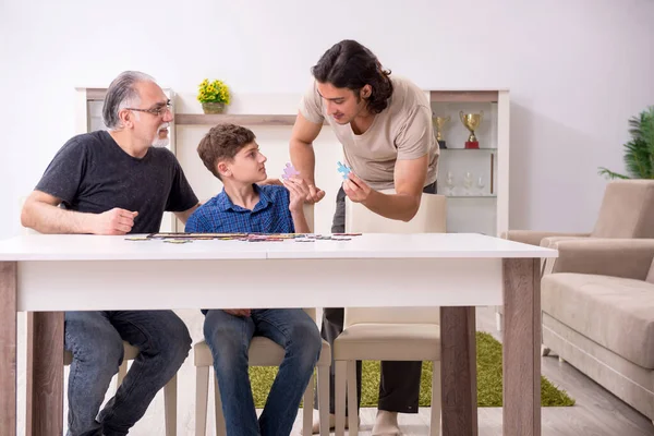 Tre generazioni di famiglia che giocano puzzle game — Foto Stock