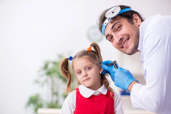 Маленькая девочка посещает молодого врача-оториноларинголога — стоковое фото