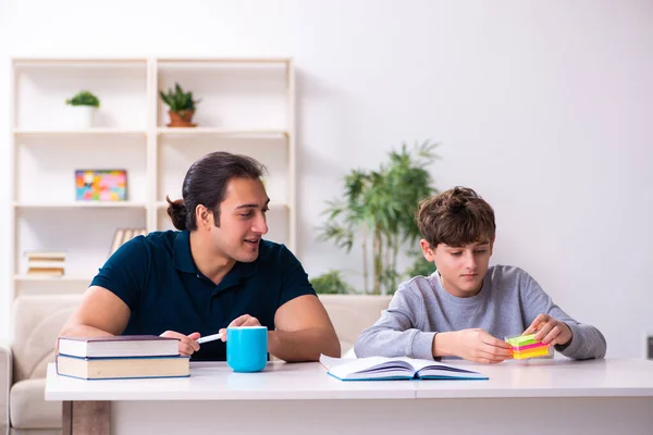 Far och son i examen förberedelse koncept — Stockfoto