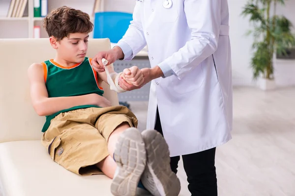 Больной мальчик навещает молодого врача-педиатра — стоковое фото