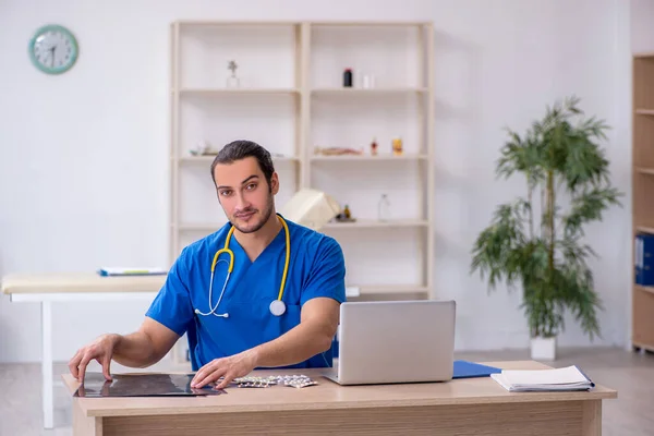 Ung manlig röntgenläkare som arbetar på kliniken — Stockfoto