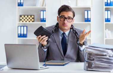 Ofis masasına zincirlenmiş meşgul bir çalışan.