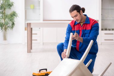 Genç erkek marangoz içeride çalışıyor.