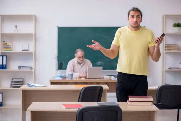 Régi tanár és fiatal férfi diák az osztályteremben — Stock Fotó