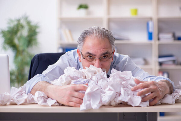 Старый бизнесмен отвергает новые идеи кучей бумаг