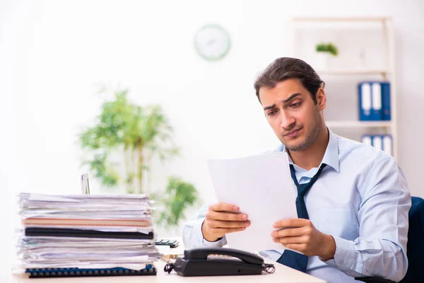 Joven empleado masculino infeliz con el trabajo excesivo —  Fotos de Stock