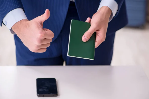 Молодий бізнесмен тримає паспорт, який готується до поїздки — стокове фото