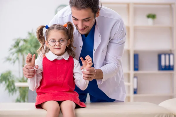 Menina pequena visitando jovem médico oculista masculino — Fotografia de Stock