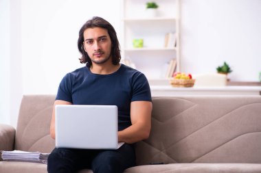 Evden çalışan genç bir adam.