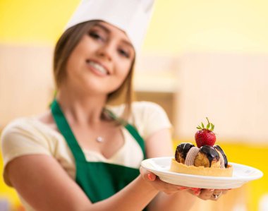 Genç aşçı mutfakta kek pişiriyor.