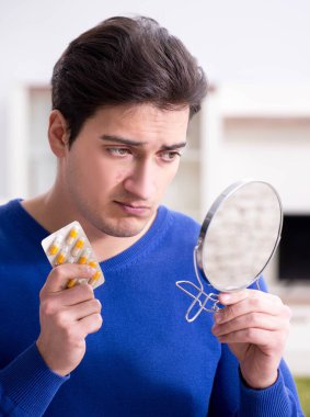 Genç yakışıklı adam yüz derisi ile ilgileniyor.