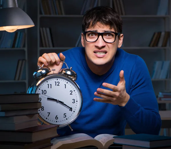 Estudante se preparando para exames tarde da noite na biblioteca — Fotografia de Stock