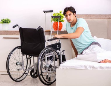 Genç yakışıklı engelli adam evde iyileşiyor.