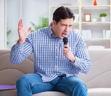 Evde karaoke yapan komik adam.