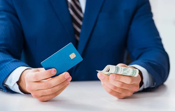Empresário segurando dinheiro dólar e cartão de crédito — Fotografia de Stock