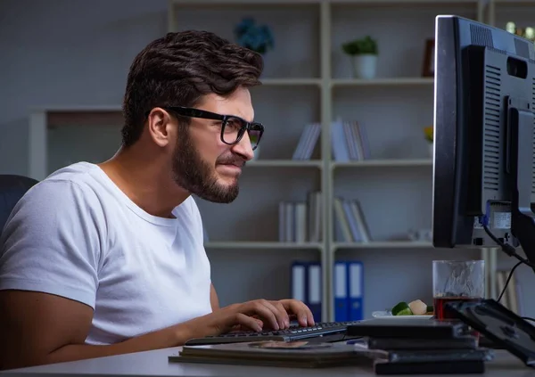 Jeune homme restant tard au bureau pour faire des heures supplémentaires — Photo