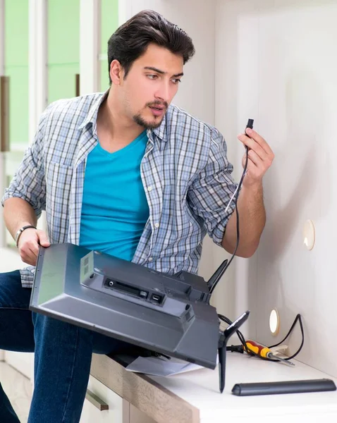 Genç adam evde televizyon tamir ediyor. — Stok fotoğraf