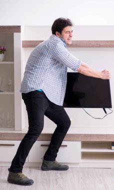 Bozuk televizyonu tamir etmeye çalışan adam