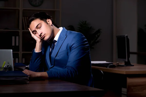 Jeune employé de sexe masculin travaillant la nuit au bureau — Photo