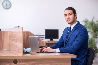 Genç yakışıklı işadamı ofiste çalışıyor.