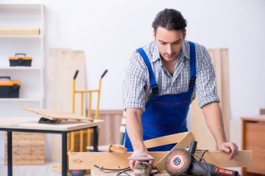 Genç erkek marangoz içeride çalışıyor.