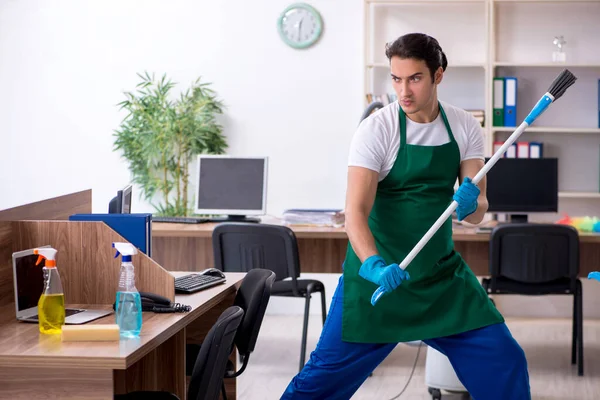 젊고 잘생긴 청부업자가 사무실 청소하는 모습 — 스톡 사진